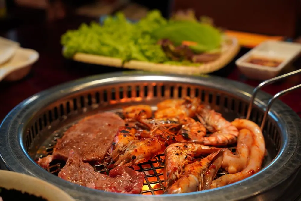 A wok of glossy Korean sweet-and-spicy fried chicken up close
